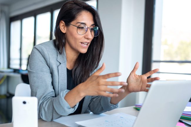 Confident business woman looking and speaking through the webcam